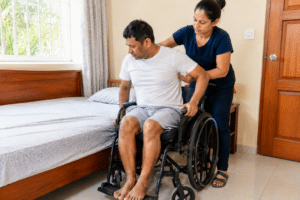 a women helping a person to get in bed from the wheelchair